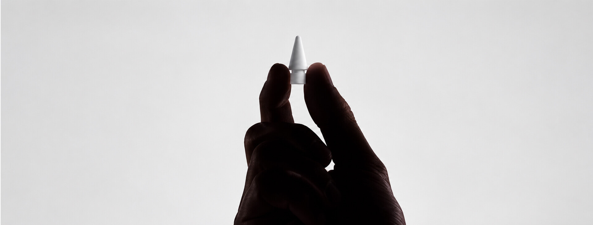 手指捏住 Apple Pencil 替換筆尖，示意檢查筆尖磨損與更換狀態