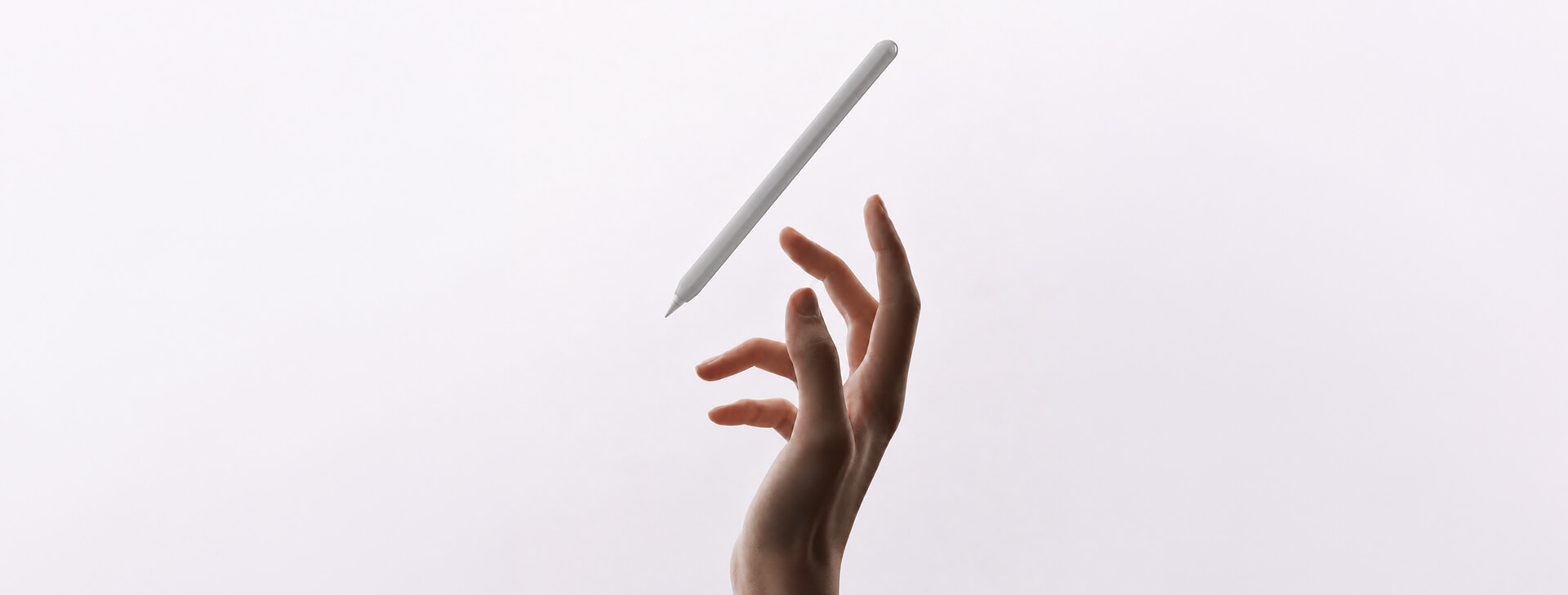 淺色背景中手部伸向白色 Apple Pencil，呈現握持與筆套選擇的使用情境