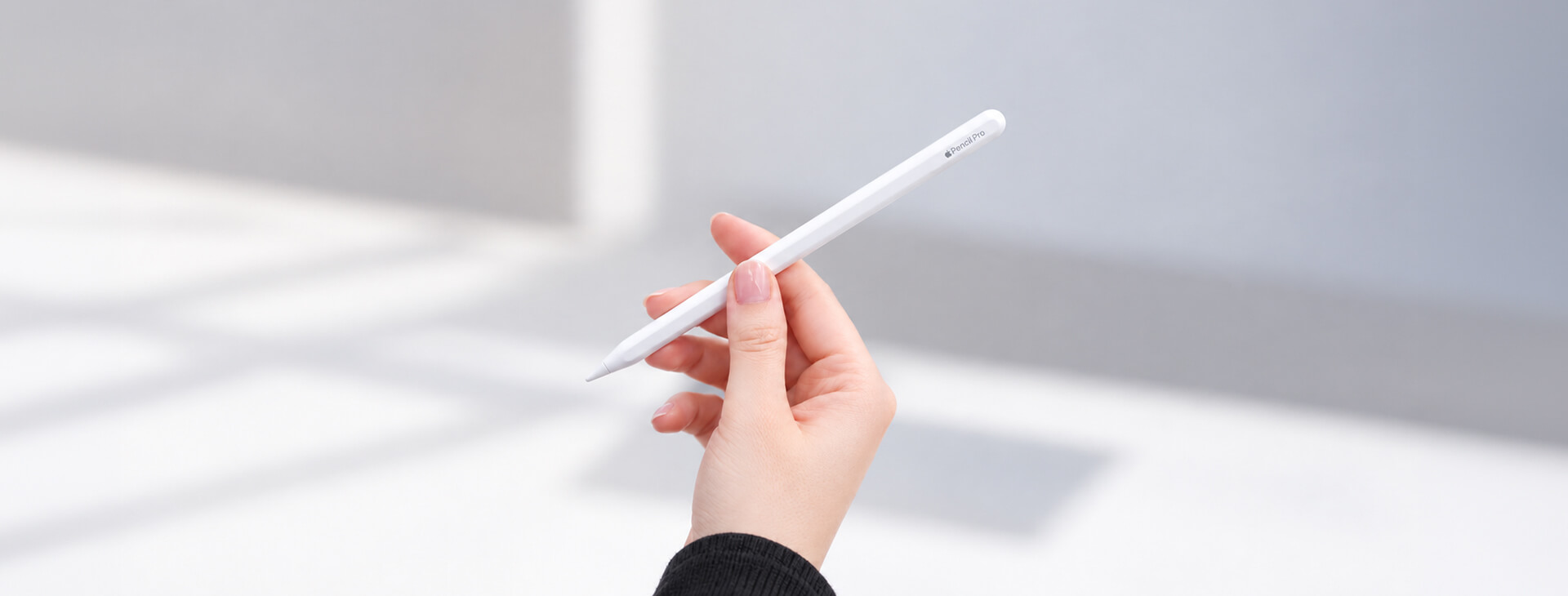 手部拿著白色 Apple Pencil，呈現檢查筆尖安裝狀態的使用情境