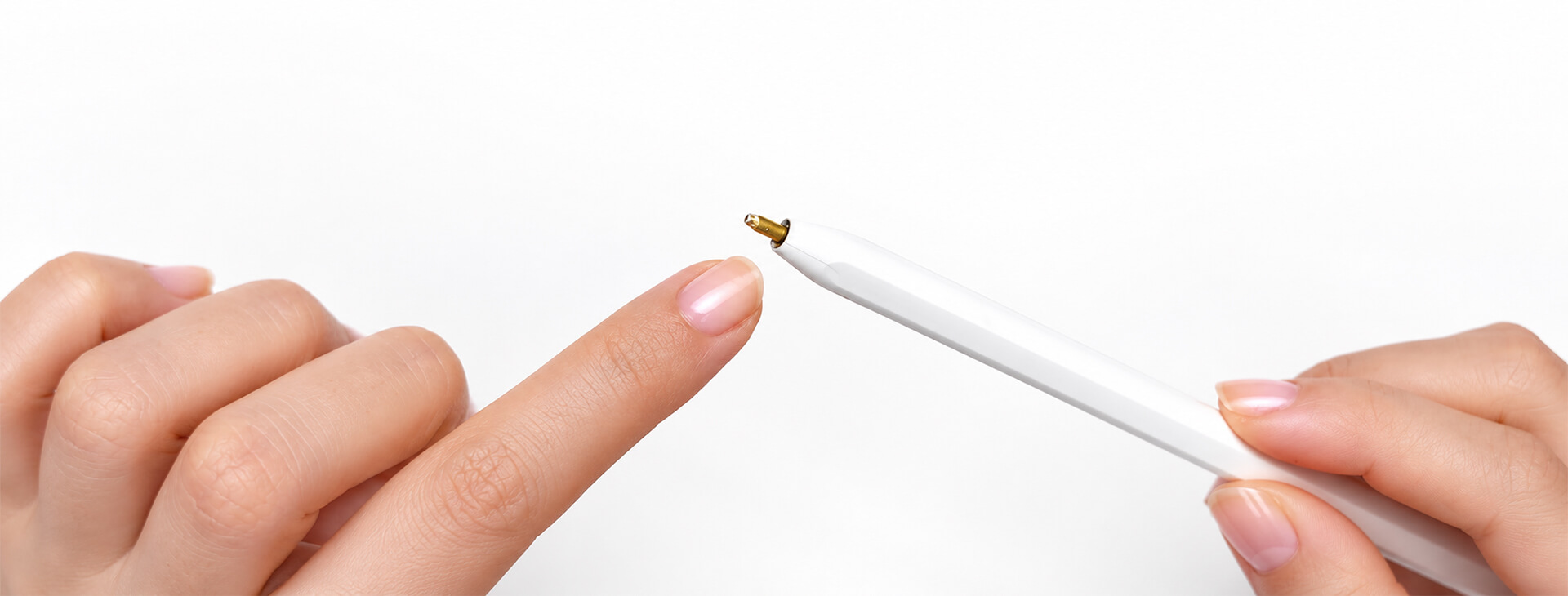 手指指向摔落後筆尖斷裂並露出金色接點的白色 Apple Pencil